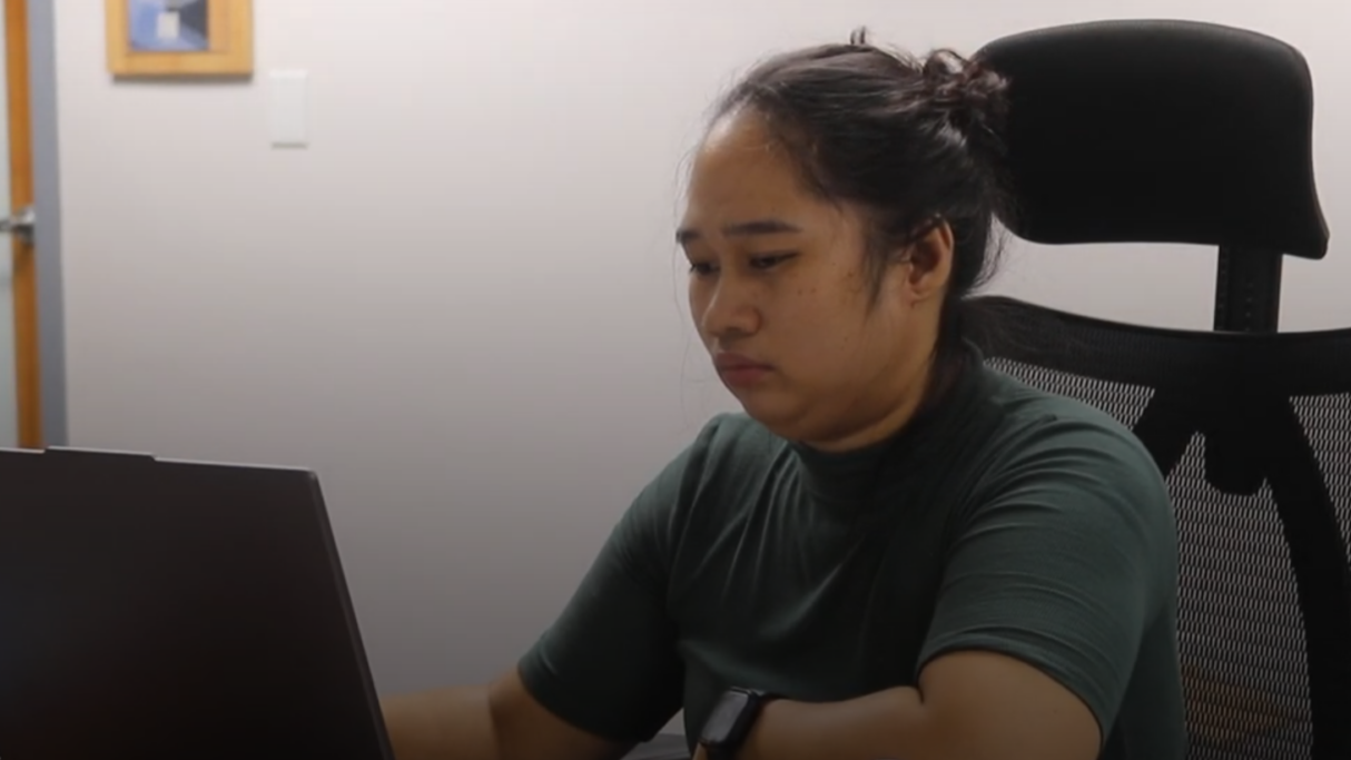 Image of an office worker typing on a laptop.